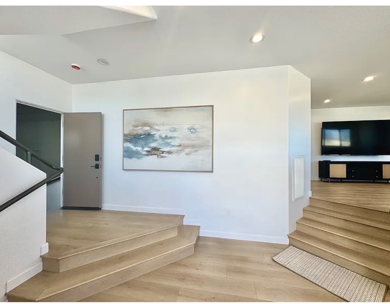 Entry foyer with wide oak steps rising toward the living levels