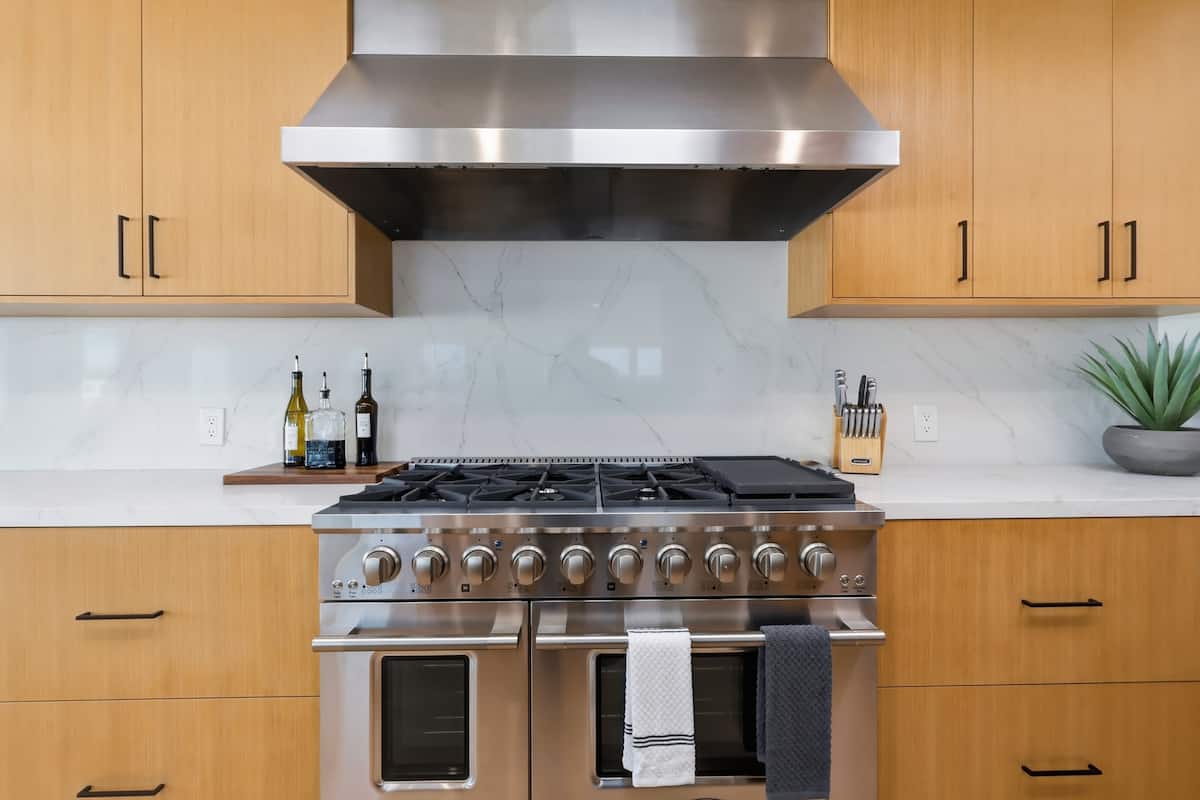 Professional range hood and warm wood cabinetry