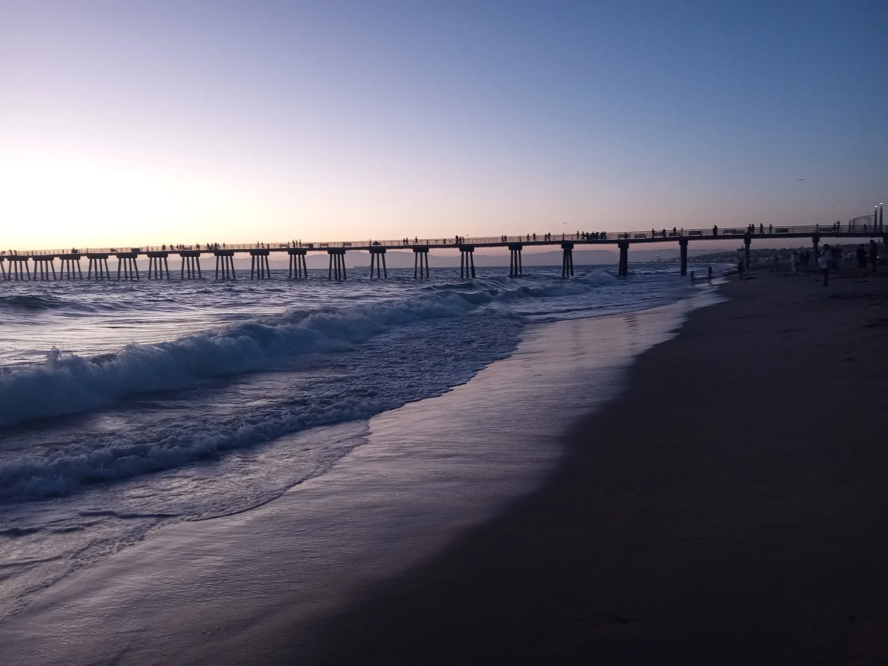 Hermosa Beach Pier silhouetted against a golden sunset
